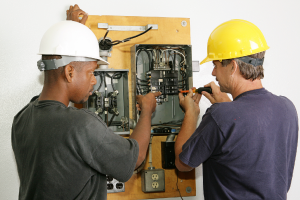 Two electricians wiring a control box